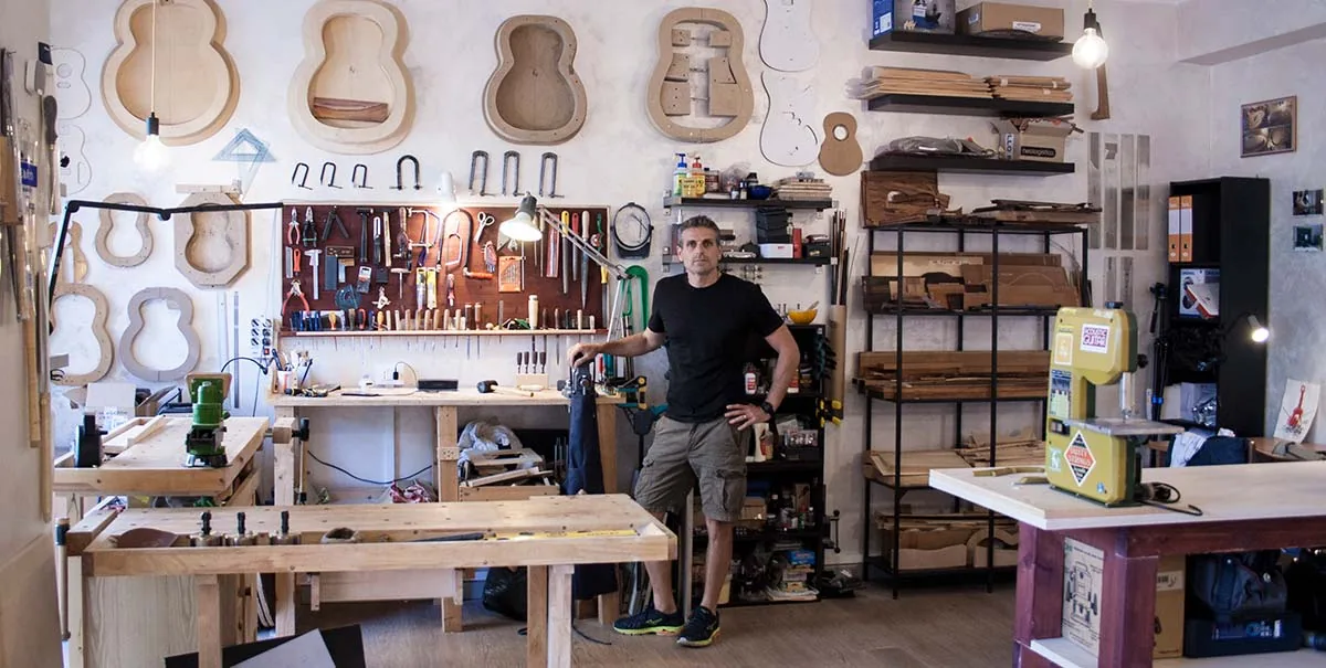 The UMA LAB lutherie workshop: workbench, soundbox templates on the walls and hand tools.