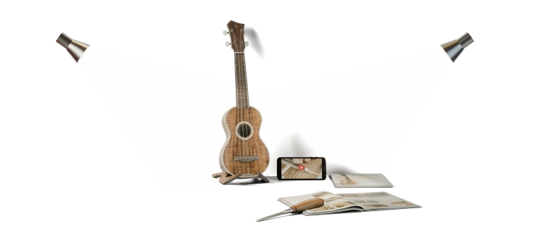 Ukulele artigianale, libro e scalpello su un telo da lavoro